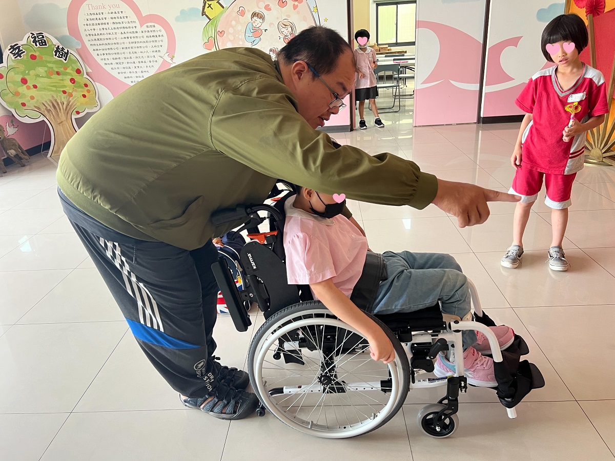 家園寶貝學習自己推輪椅(標題圖檔)